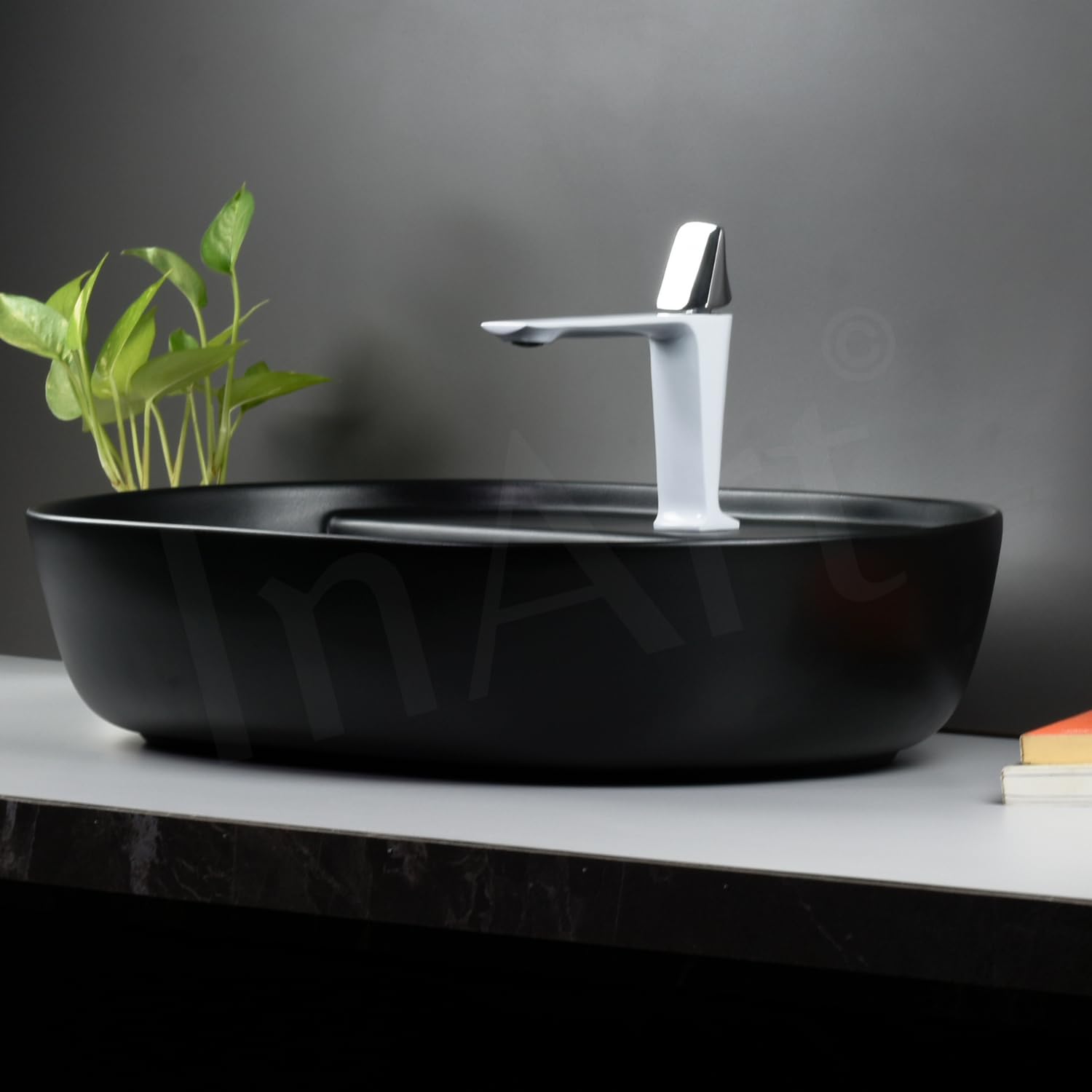 Black ceramic table top wash basin, oval shape, side angle showing slim rim and matte finish for washroom