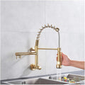 Gold wall mount kitchen sink faucet with pull-down sprayer, side angle view of high arc gooseneck spout