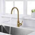 Brushed gold kitchen sink mixer tap installed in modern Indian kitchen, high arc swivel spout in use