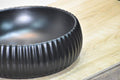 Matte black table top wash basin in modern bathroom interior, premium ceramic round basin for washroom counter