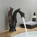 Brass basin tap with swan neck design installed on wash basin, modern bathroom interior lifestyle shot