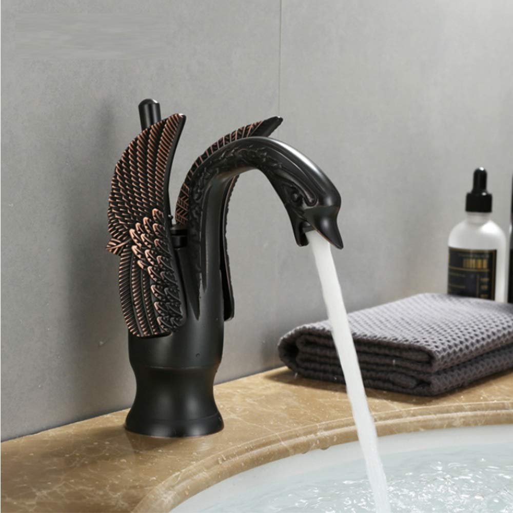 Brass basin tap with swan neck design installed on wash basin, modern bathroom interior lifestyle shot
