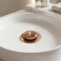 Half-cap pop-up drain fitting for bathroom wash basin installation