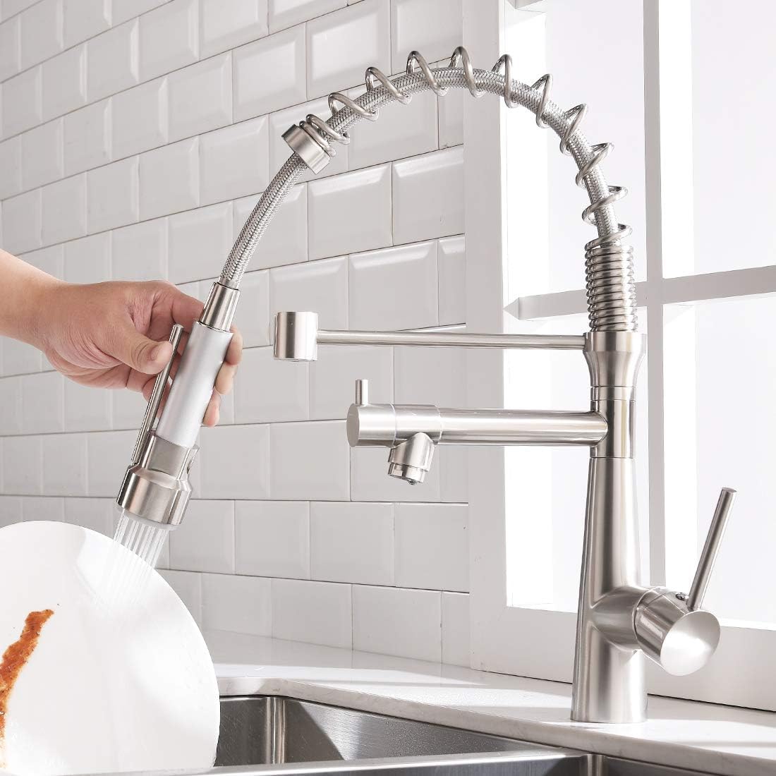 Kitchen taps and mixers detail of 360° swivel gooseneck spout and pull-down hose in brushed chrome