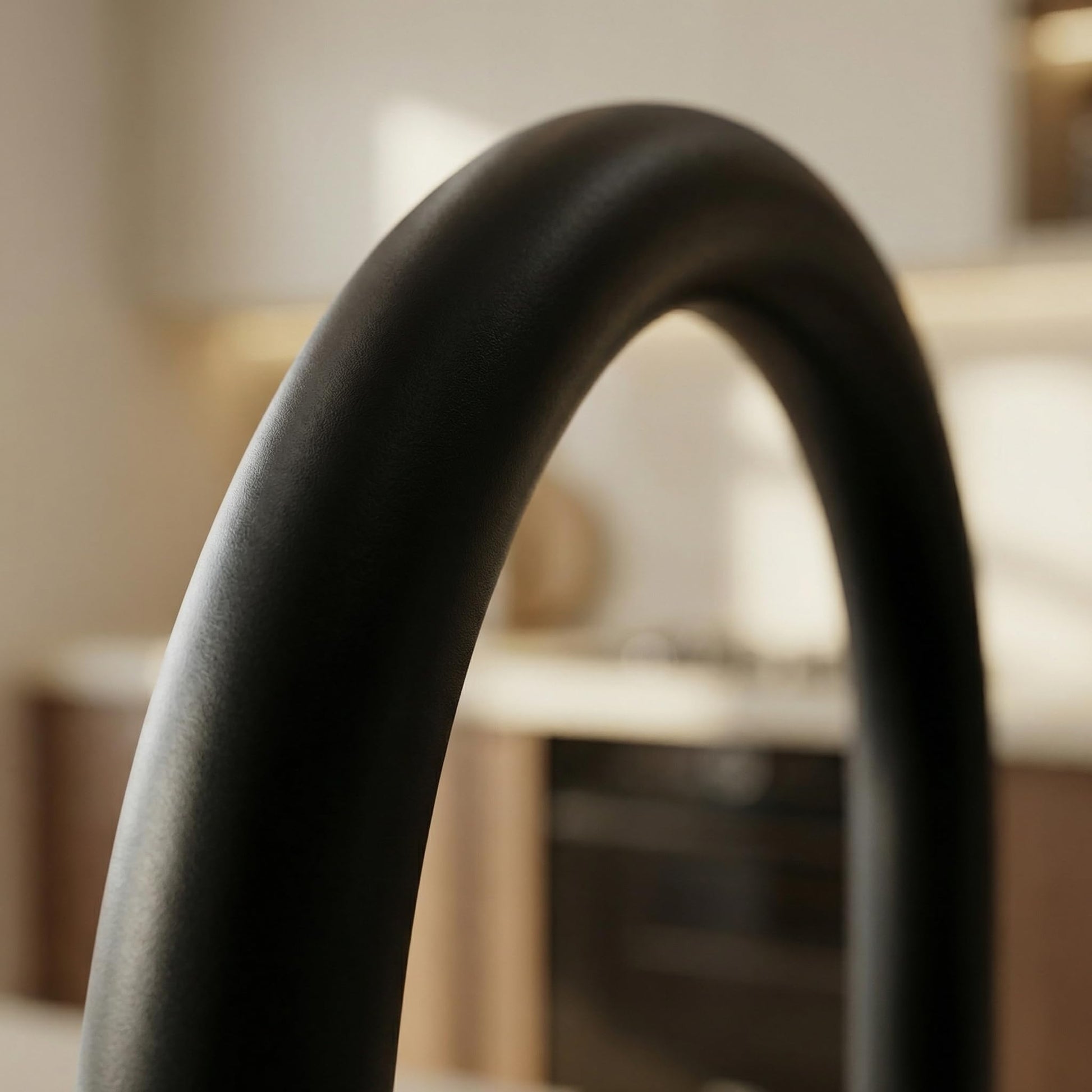 Detail view of 360° swivel spout on matte black kitchen sink faucet, smooth water outlet design