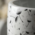 Close-up of black floral print on glossy white ceramic pedestal wash hand basin, premium sanitaryware finish