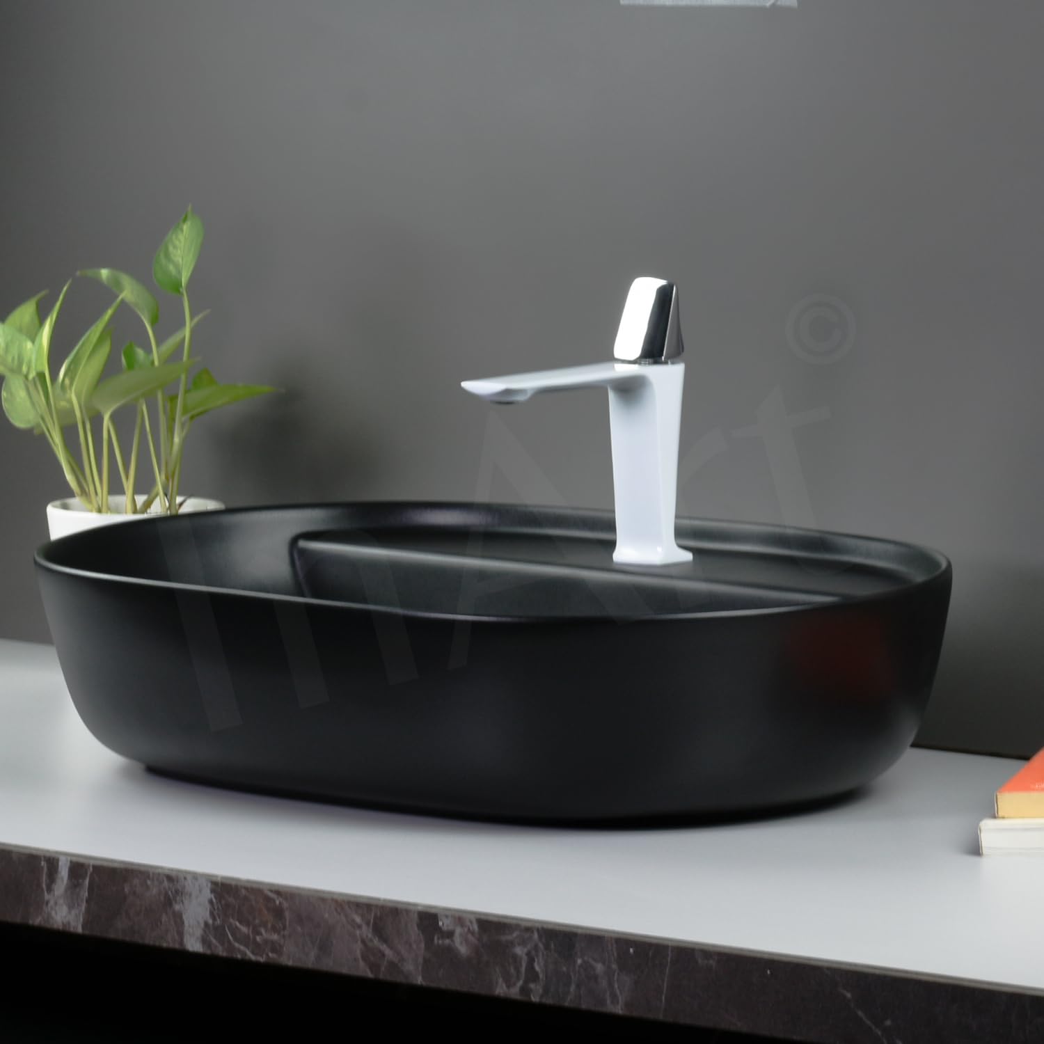 Counter top wash basin black ceramic with smooth matte texture, close-up detail of oval rim and drain area