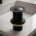 Matt black pop-up waste coupling for wash basin with half-cap top view