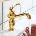 Close-up of gold finish waterfall wash basin taps showing single lever handle and brass body, InArt mixer tap