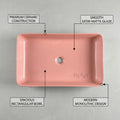 Designer vanity wash basin in pink ceramic, rectangular table top basin design, angled view