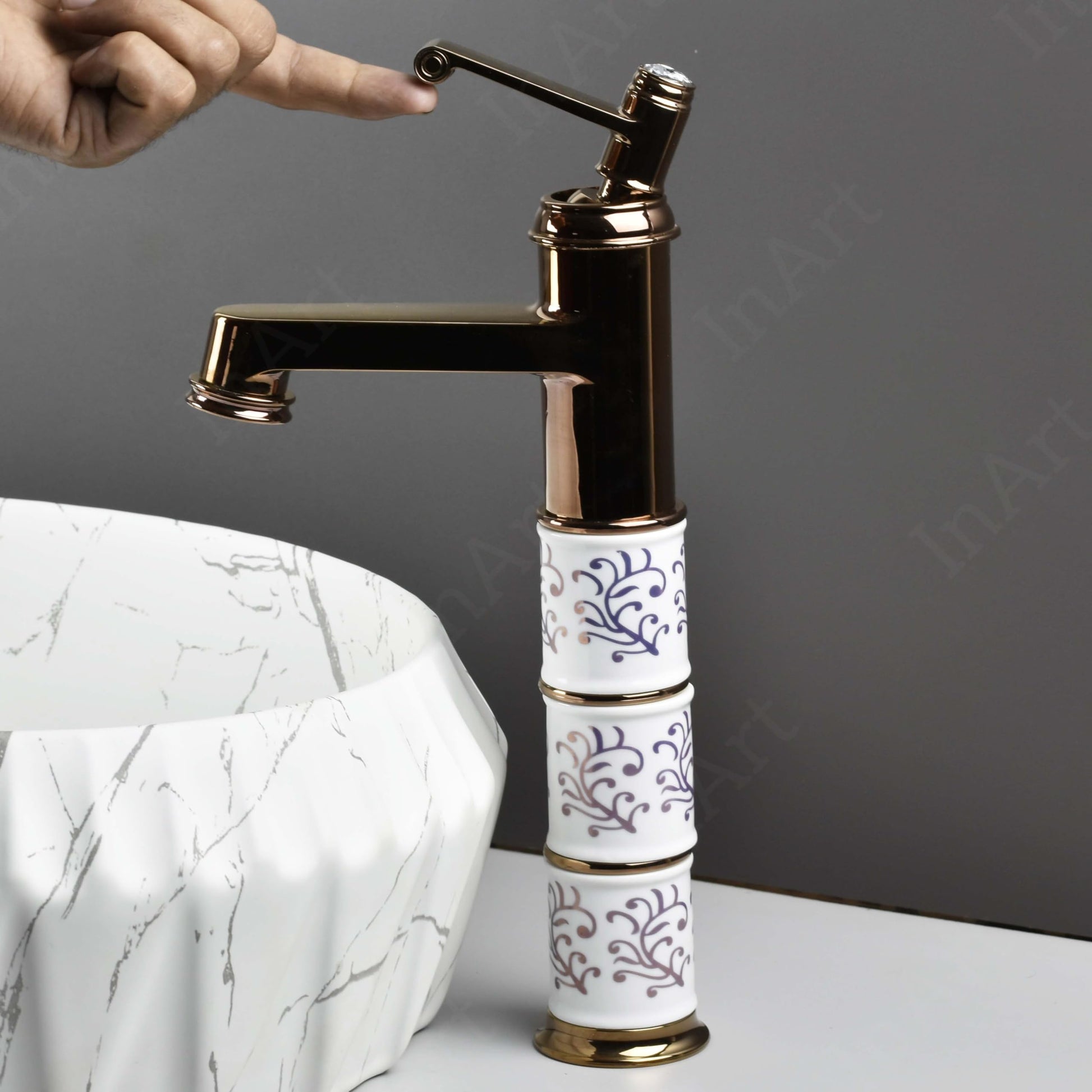 Close-up of InArt waterfall spout on rose gold basin mixer tap, smooth flow design in zinc alloy