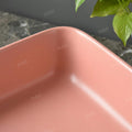 Close-up of InArt ceramic wash basin waste coupling hole on pink table top basin, premium finish