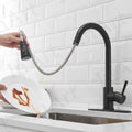 Black sink tap installed in modern Indian kitchen, high arc pull out spray tap for easy dishwashing
