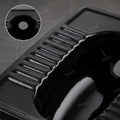 Close-up of black glazed ceramic surface on Indian style toilet pan
