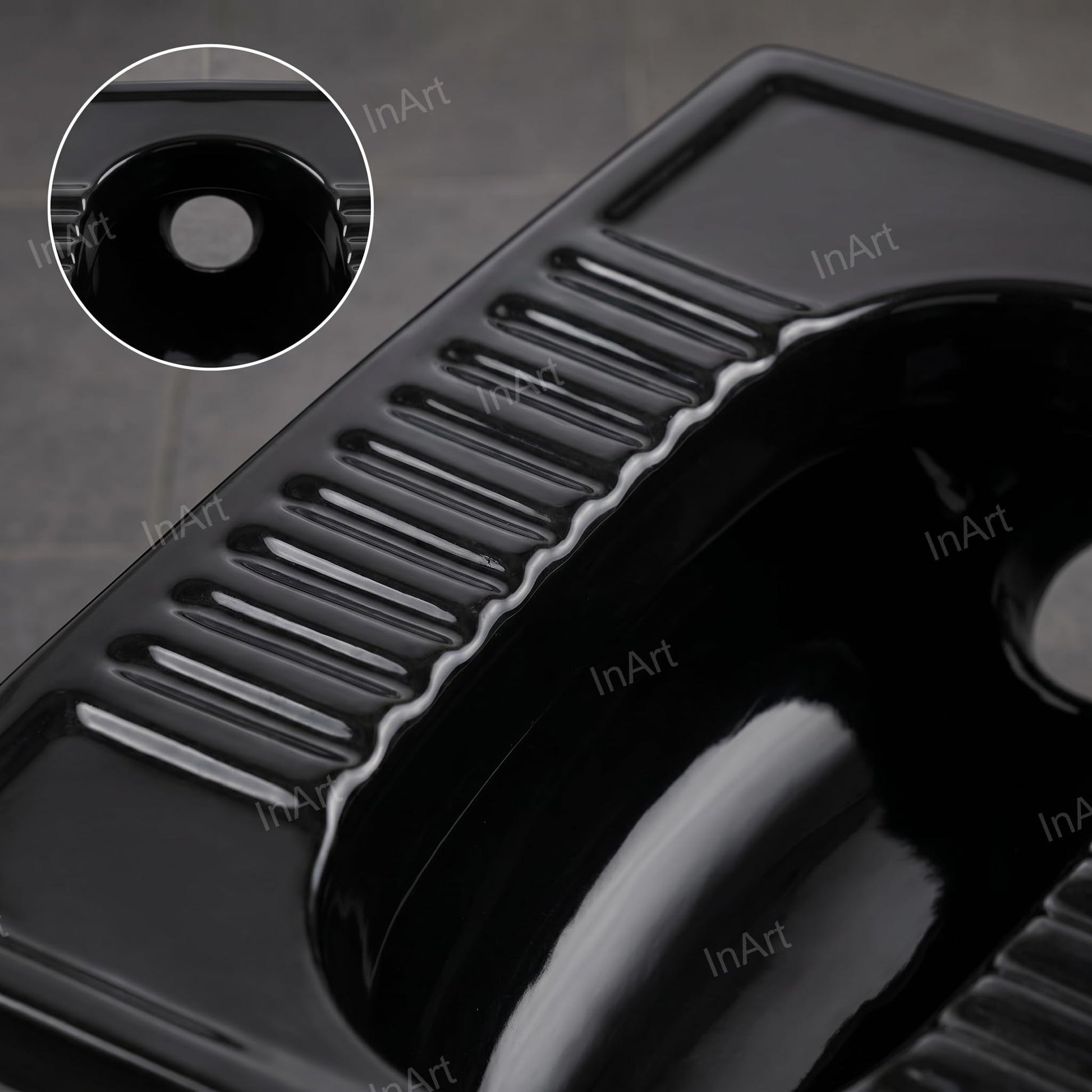 Close-up of black glazed ceramic surface on Indian style toilet pan