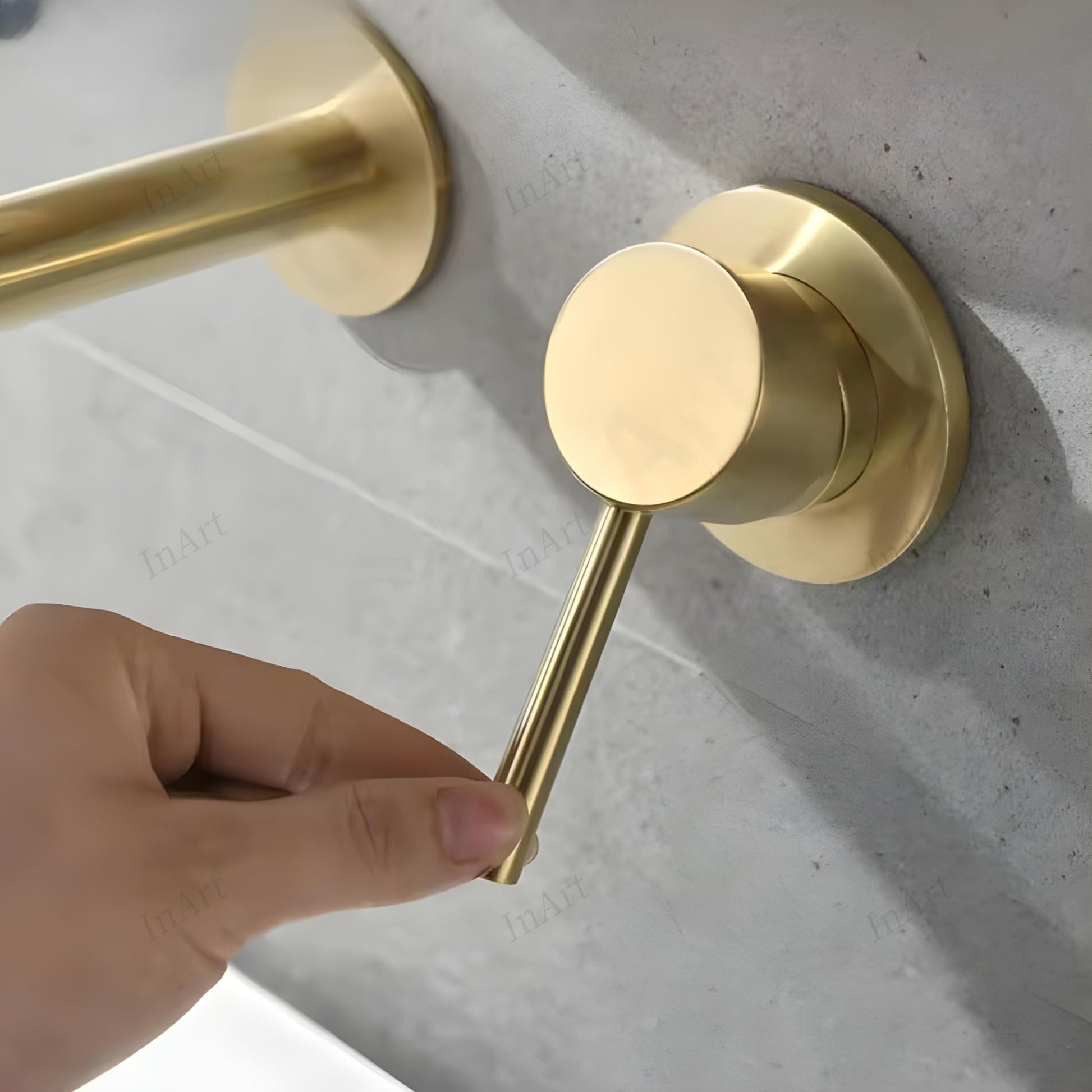 Close-up of brushed golden finish on brass wall mounted basin mixer, premium modern bathroom tapware