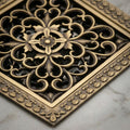 Close-up of square brass jali cover in antique bronze finish, durable floor drain for bathroom use
