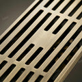 Close-up of antique brass floor drain jali slots with anti-foul cockroach trap for washroom drainage