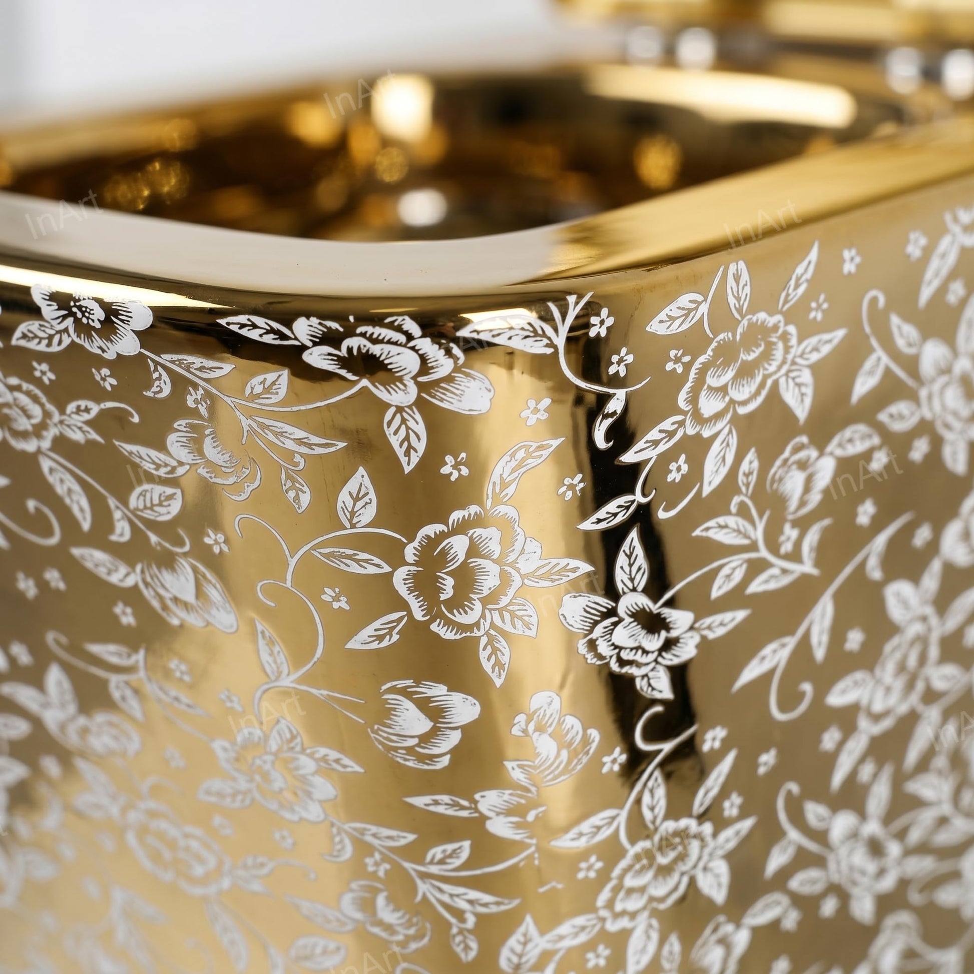 Close-up of soft close toilet seat cover on square wall hung commode, glossy white ceramic with gold leaf design