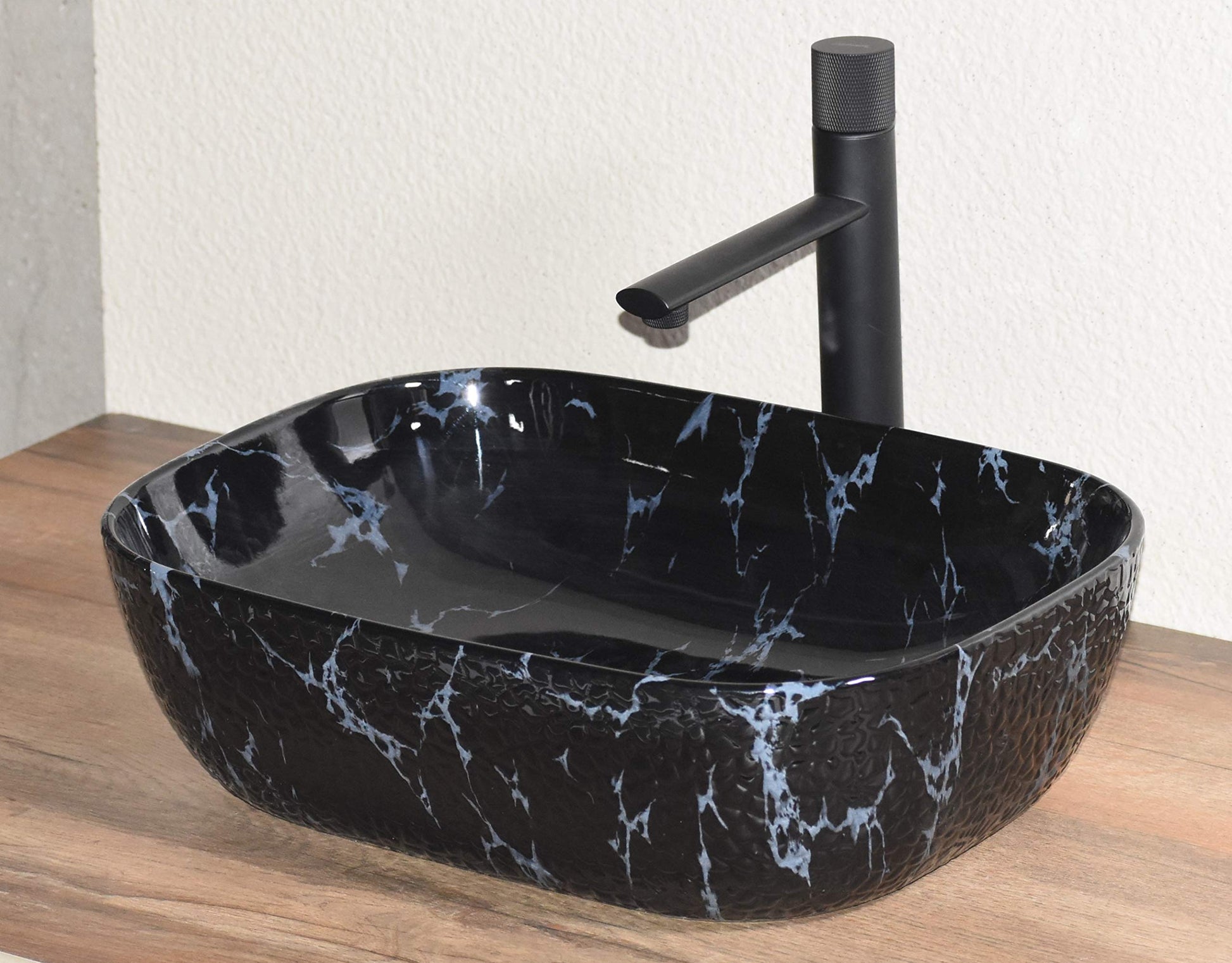 Designer table top basin design in black marble finish, rectangular ceramic wash basin angled view