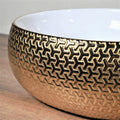 InArt ceramic table top wash basin in glossy gold, styled on bathroom counter with tap for luxury look