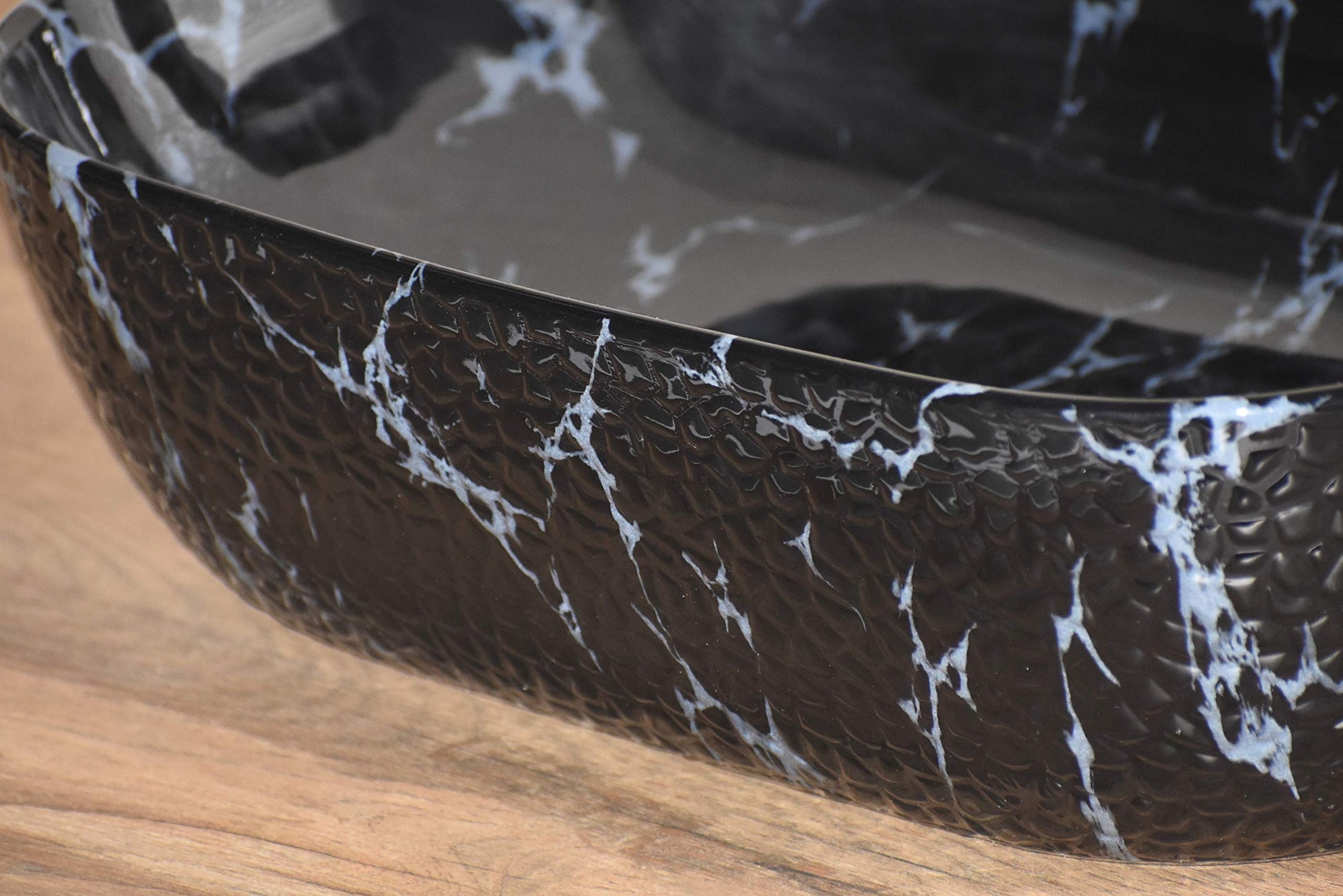 Close-up of glossy black marble colour ceramic table top wash basin rim and smooth finish detail