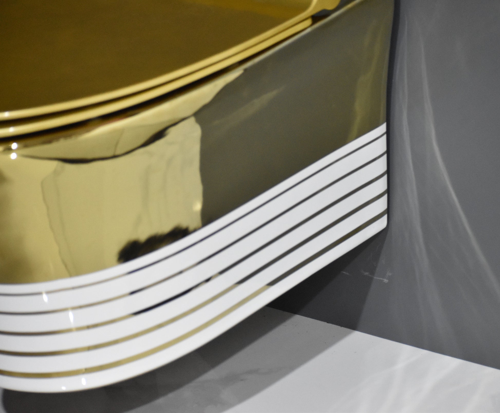 InArt ceramic gold wall hung toilet seat - close-up detail of designer mounting and finish